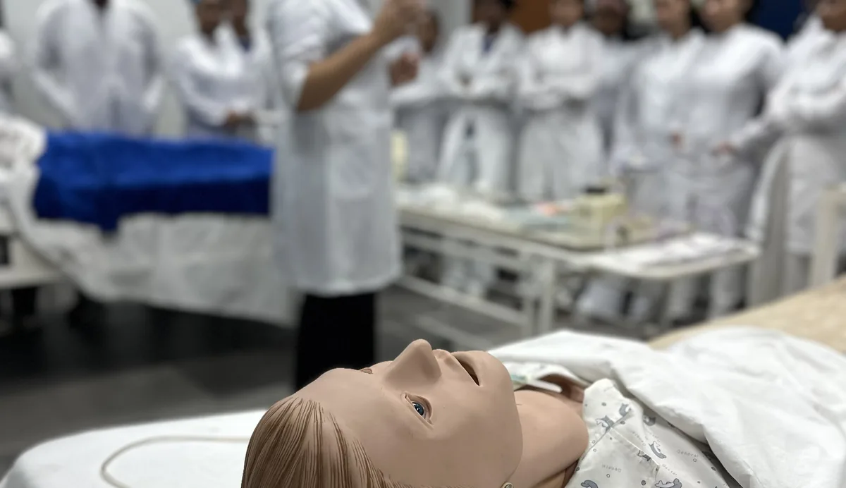 Turma de enfermagem em treino com manequim de simulação